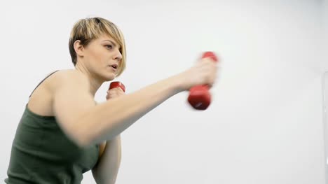 Woman-training-arms-with-dumbbells-and-imitates-boxing-movements