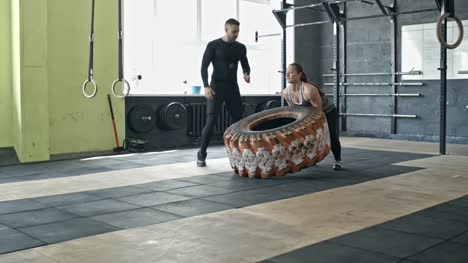 Woman-Performing-Tire-Flips-at-Personal-Workout-with-Coach
