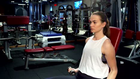 A-hard-working-girl-is-training-her-arms-with-dumbbells
