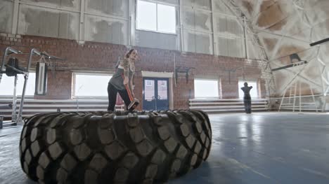 Woman-Doing-Sledgehammer-Exercise-with-Tire