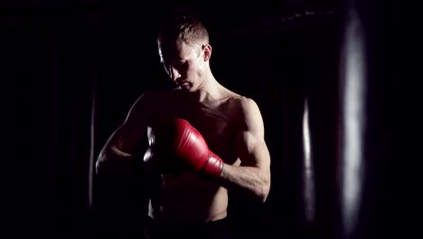 Boxer-setzt-auf-Boxhandschuhe.-Männliche-Kämpfer,-seine-Handschuhe-auf,-in-Zeitlupe.-Kickboxer,-immer-bereit-zu-trainieren,-Handschuhe-anziehen