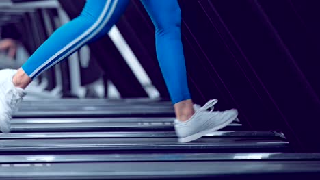 Adult-woman-runs-on-treadmill-at-the-fitness-centre.-Attractive-sporty-girl-running-on-the-treadmil