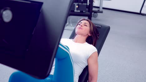 Adult-woman-makes-a-аoot-press-in-the-simulator.-Fitness-girl-workout-with-simulator-leg-press-at-gym