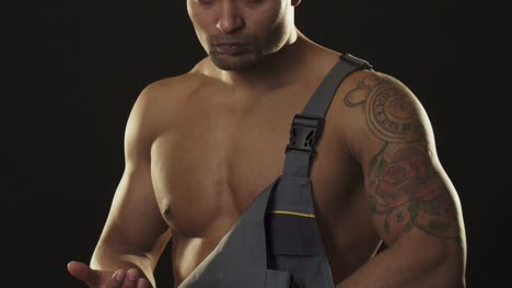 Ripped-muscular-mechanic-in-workwear-looking-aggressive-holding-a-wrench