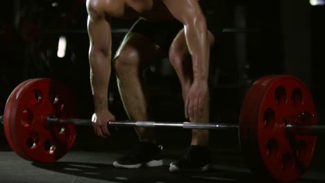 Sportsman-Doing-Barbell-Deadlift-Exercise-in-Dark-Gym