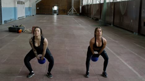 Athletic-Women-Training-with-Kettlebells