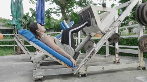 Mujer-asiática-empujar-equipos-de-peso-por-pierna