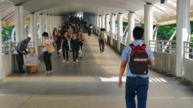 Zeitraffer-vieler-Menschen-gehen-an-ihren-Arbeitsplatz-im-Geschäftsviertel-von-Bangkok-mit-öffentlichen-Nahverkehrssystem-in-Chong-Nonsi-BTS-Station-im-morgendlichen-Berufsverkehr.