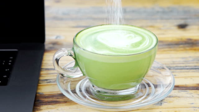 Slow-Motion-von-Hand-rühren-Sie-eine-Tasse-Milch-grüner-Tee