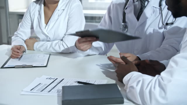 Médicos-discutir-documentos-y-estrechar-las-manos