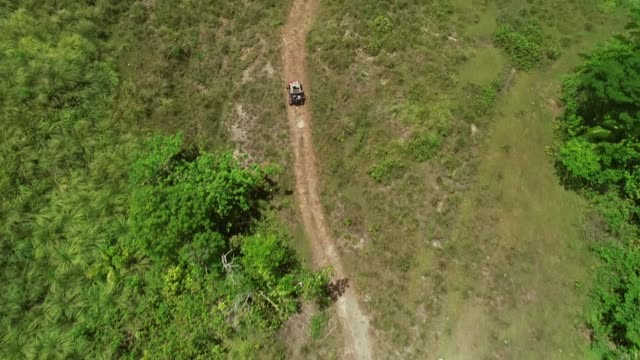 Aerial-view-of-quadricycle-doing-trail-next-Chocolate-Hills-Complex,-Batuan.