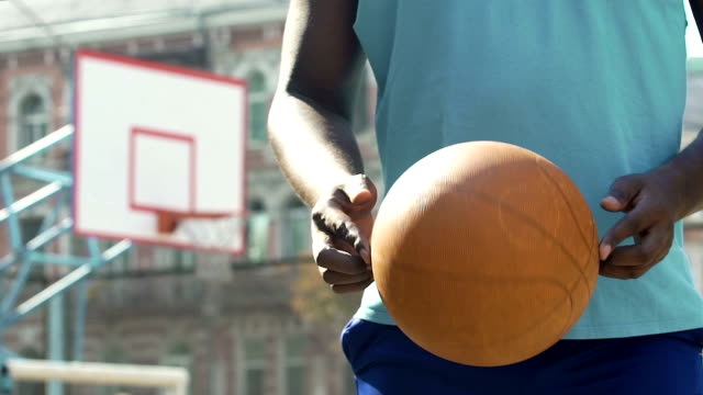 Jugador-profesional-de-baloncesto-con-pelota,-alentando-a-los-jóvenes-para-practicar-deportes