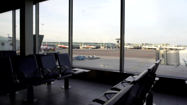Leere-Sitze-der-Abflug-Lounge-am-Flughafen,-Blick-auf-die-Start-und-Landebahn-durch-Fenster
