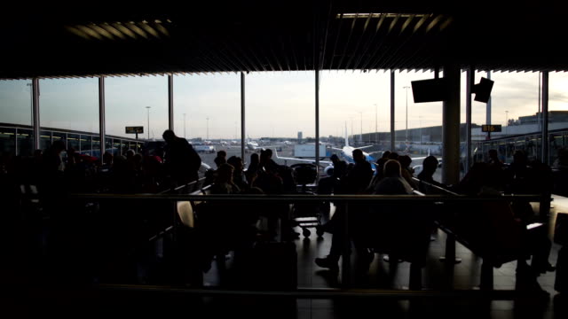 Tourists-waiting-for-boarding-at-departure-lounge,-people-sitting-in-airport