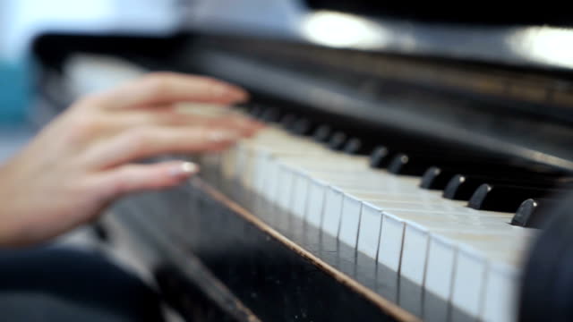 Female-hand-gently-touches-piano-keys