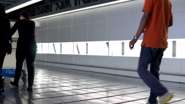 Pasajeros-caminando-por-el-corredor-de-la-calzada-a-la-terminal-en-el-aeropuerto-internacional-de-Suvarnabhumi.-Vídeo-de-4-K