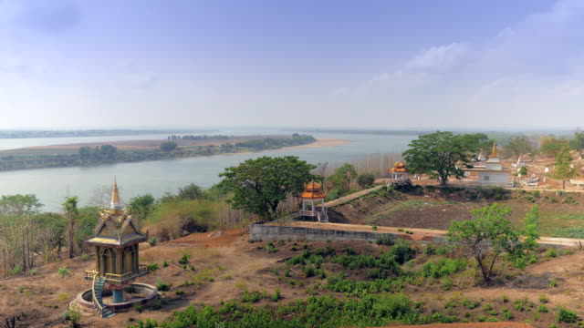 Stupas-und-Gräber-in-buddhistischen-Friedhof-am-Flussufer-mit-Mekong-Insel