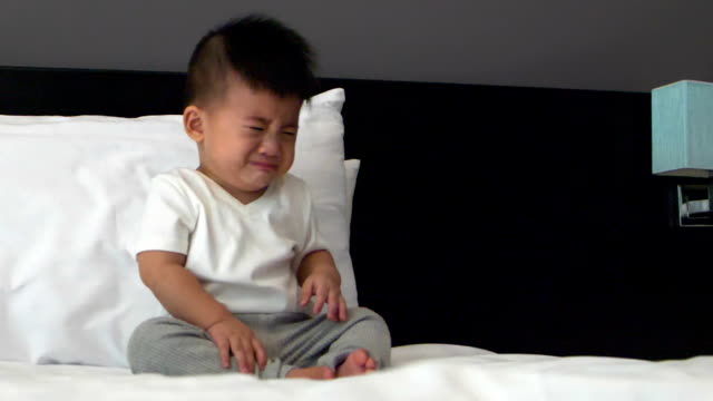Baby-boy-crying-on-the-white-bed,-Slow-motion