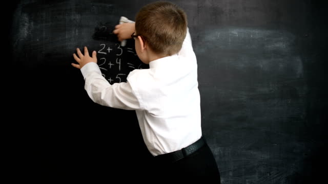 Kleiner-Junge-waschen-Tafel-nach-Mathematik-Ausdrücken-zu-lösen.-Kreatives-Konzept-zurück-zu-Schule-und-Studium.-Vorschule