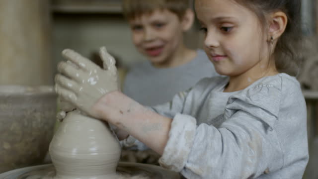 Kleines-Mädchen-macht-Ton-Vase-in-Keramik-Klasse