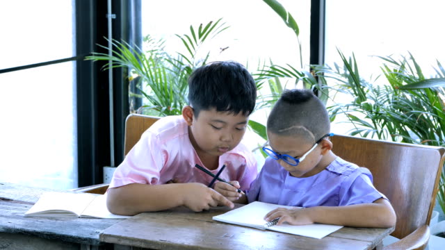 Gente-de-Asia-muchacho-dos-con-tareas-de-escritura.-concepto-de-educación