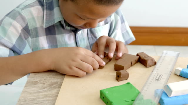 Child's-hands-playing-colorful-clay-on-table.-Development-of-fine-motor-skills-of-fingers-and-creativity,-education