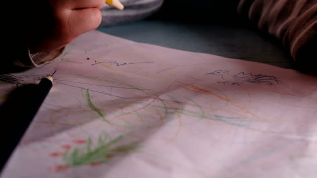 Kleines-Kind-stützt-sich-auf-ein-Blatt-Papier-mit-Buntstifte-und-Filzstifte,-lernt-auf-ein-Stück-Papier---Hausunterricht-zu-zeichnen.