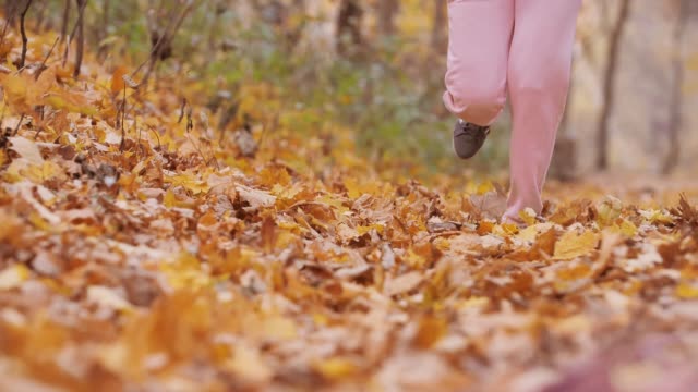 Macro-shoot-of-woman-running-in-autumn-landscape-in-super-slow-motion