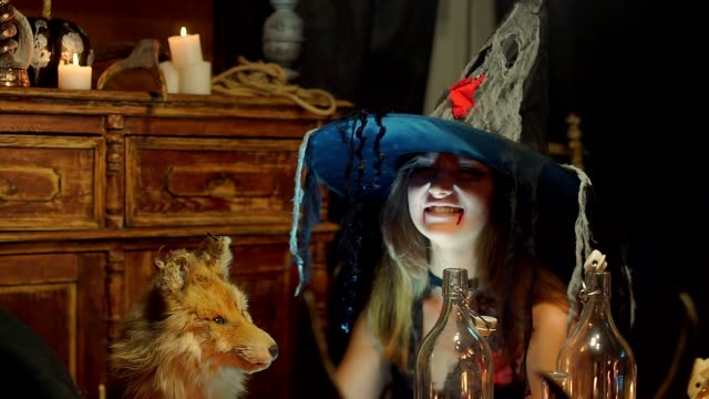 Eine-Halloween-Hexe-streichelt-einen-Toten-Fuchs-und-boshaft-lächelt