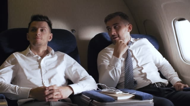 Businessmen-Chatting-and-Drinking-Champagne-on-Plane