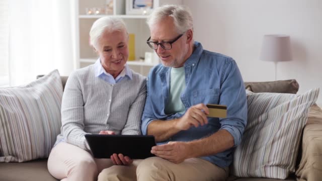 gerne-älteres-Paar-mit-TabletPC-und-Kreditkarte