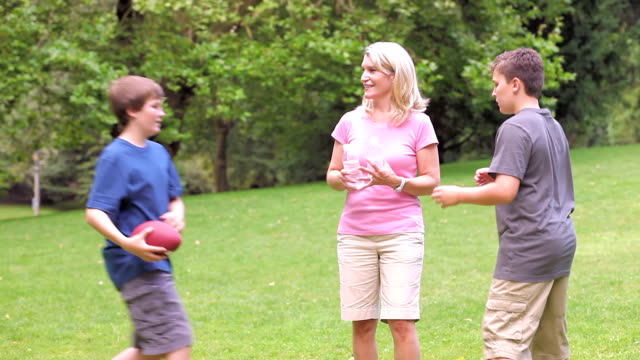 Teenage-boys-run-up-and-greet-their-mother.-Wide-Shot