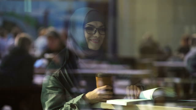 Junge-arabische-Studentin-Lesebuch-im-Café,-auf-Prüfung-vorzubereiten