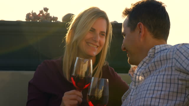 Happy-couple-having-red-wine-in-the-balcony-at-home-4k