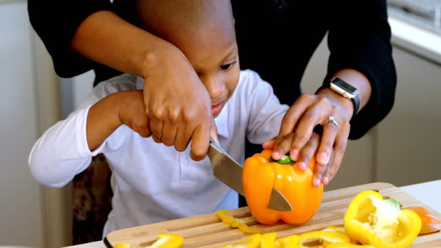 Mother-and-son-chopping-vegetables-in-kitchen-at-home-4k