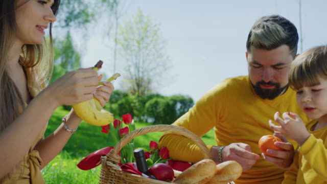 Familia-comiendo-frutas-en-un-picnic