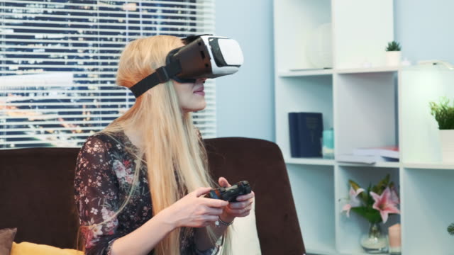 Close-up-of-attractive-woman-playing-a-game-with-joystick-in-virtual-reality-goggles-on-Christmas