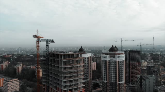 Construcción-de-edificio-residencial.-Vista-aérea-de-drones-del-centro-de-la-ciudad-con-edificios-de-gran-altura-en-un-día-nublado-gris.-Nuevas-construcciones-de-edificios-de-metrópolis
