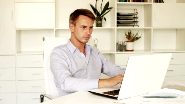 man-sitting-at-working-desk-with-laptop