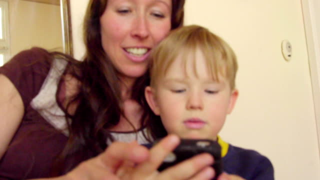 Madre-y-el-niño-juegan-con-teléfono-inteligente