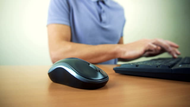 Close-up-of-hands-typing-on-computer-keyboard-and-mouse