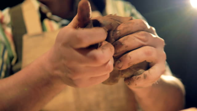 A-low-view-on-potters-fingers-pressing-into-clay-to-knead-it.