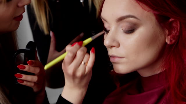 Make-up-Künstler-malt-Augenlider-an-den-Client-in-einem-Schönheitssalon