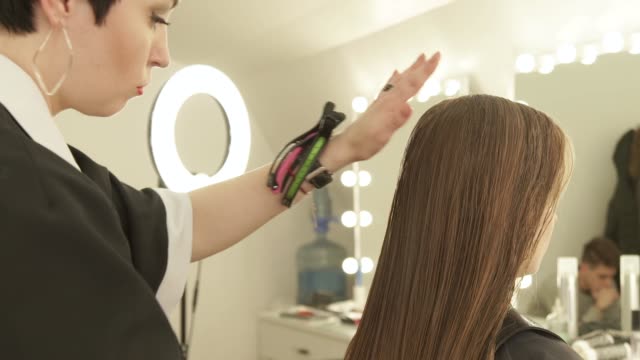 Hairdresser-combing-long-hair-before-female-haircut-in-hairdressing-salon.-Close-up-woman-hairstyle-in-beauty-salon.-Hairdresser-preparing-to-haircutting-wet-hair
