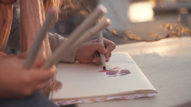 Mädchen-ist-draußen-im-Park,-close-up-der-Hände-mit-Markern-und-Bild-zeichnen.