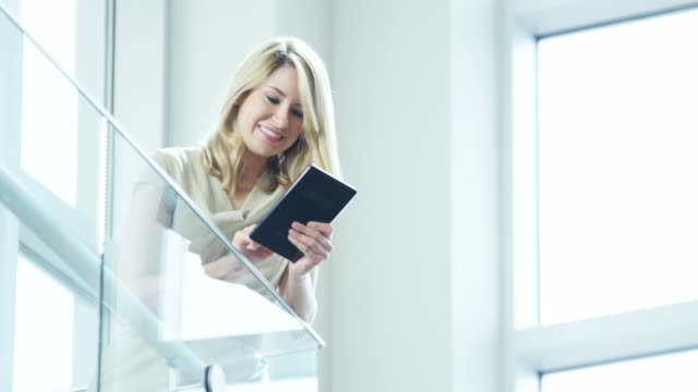 Blonde-Caucasian-businesswoman-seeing-news-on-tablet-device