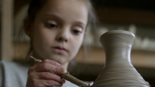 Mädchen-schmücken-Ton-Vase-aus-Keramikwerkstatt