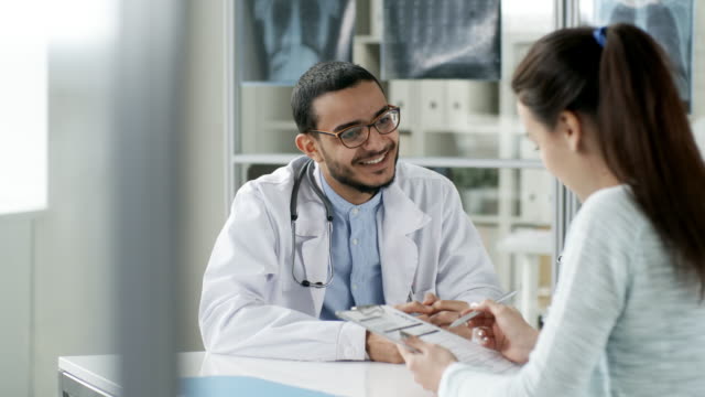 Lächelnde-Arzt-im-Gespräch-mit-der-Patientin