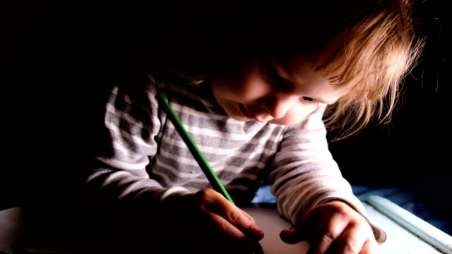 Kleines-Mädchen-zieht-grünen-Bleistift-auf-einem-Blatt-Papier-Nahaufnahme