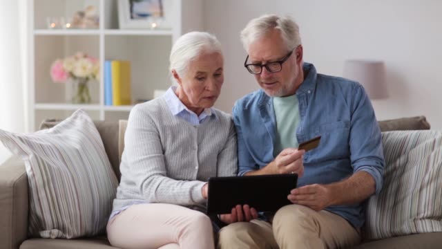 happy-senior-couple-with-tablet-pc-and-credit-card